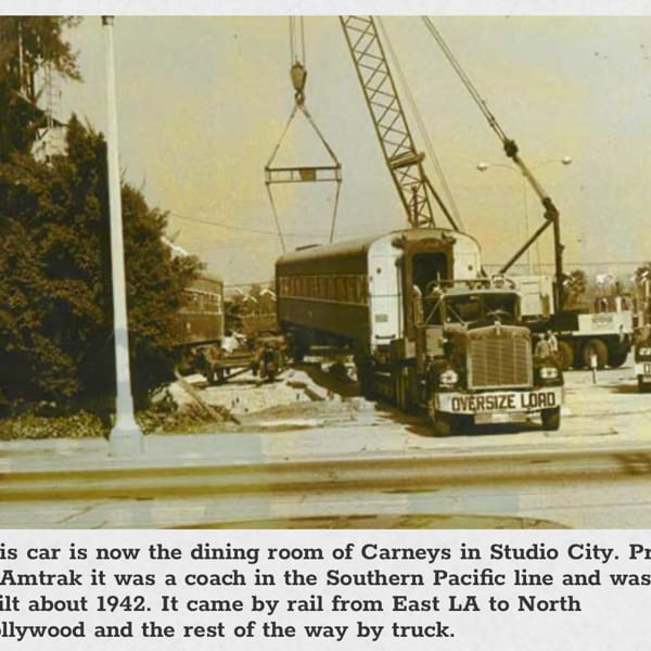 Vintage photo of a train car being transported by an "Oversize Load" truck and crane.