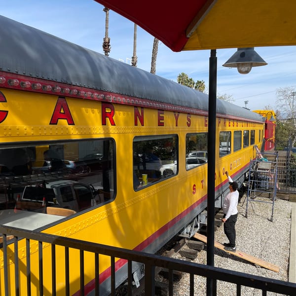 A bright yellow train car with "CARNEY'S EXPRESS" painted on its side, serving as a restaurant.